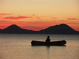 朝焼けの湖でカヌーを楽しむ