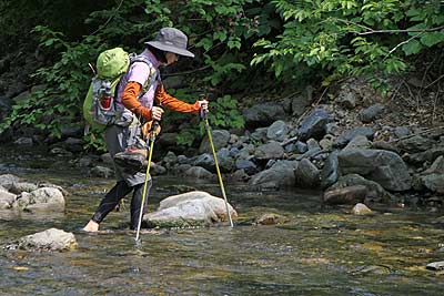 裸足になって川を渡る